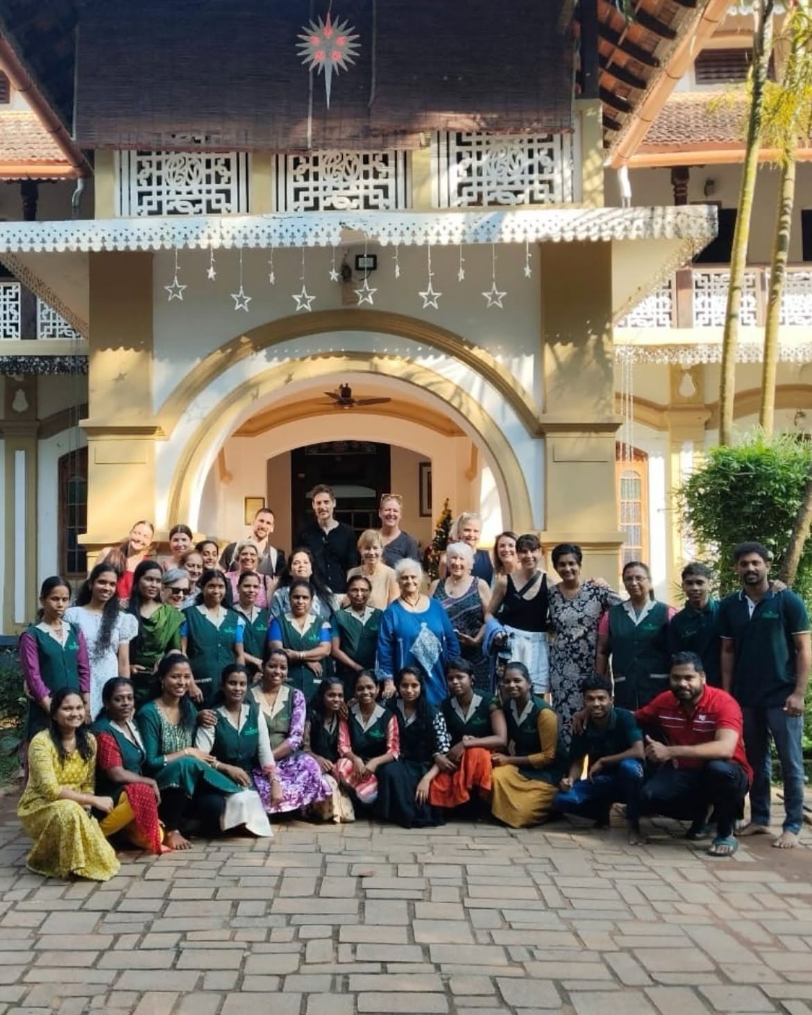 Niramayam team with international guests in front of the heritage building